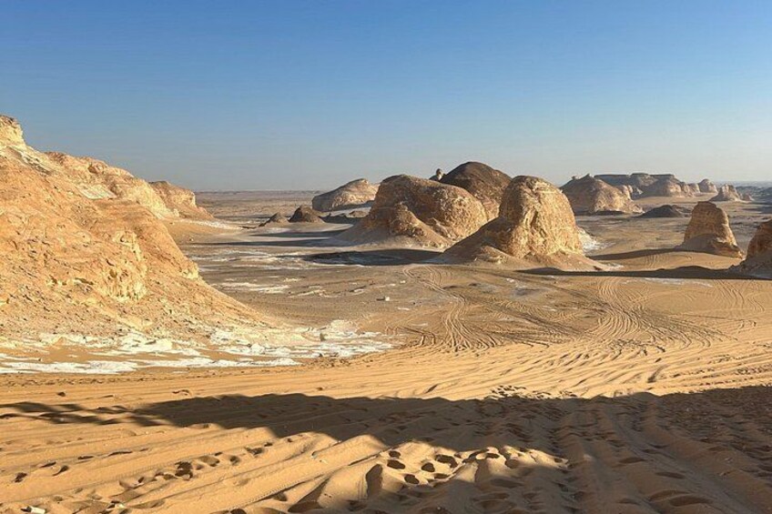 A desert landscape with sand dunes and rock formations. 3