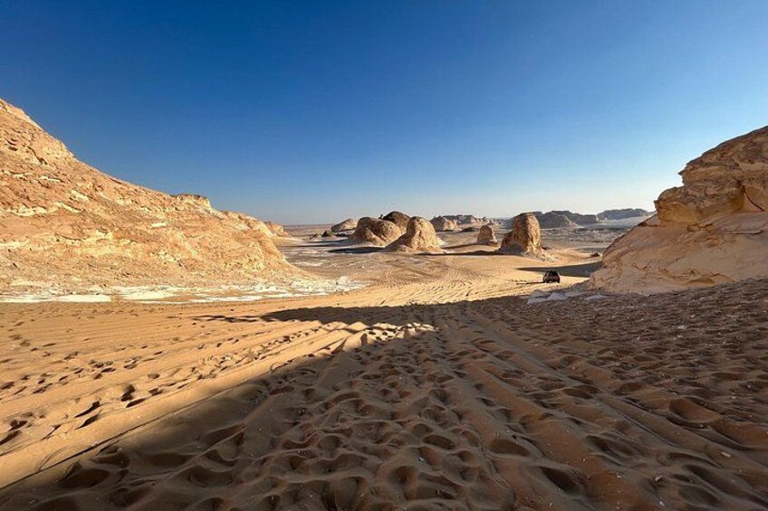 A desert landscape with sand dunes and rock formations. 2
