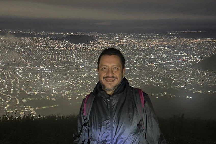 Une personne se tient sur une colline, avec une vue sur la ville en arrière-plan. 4