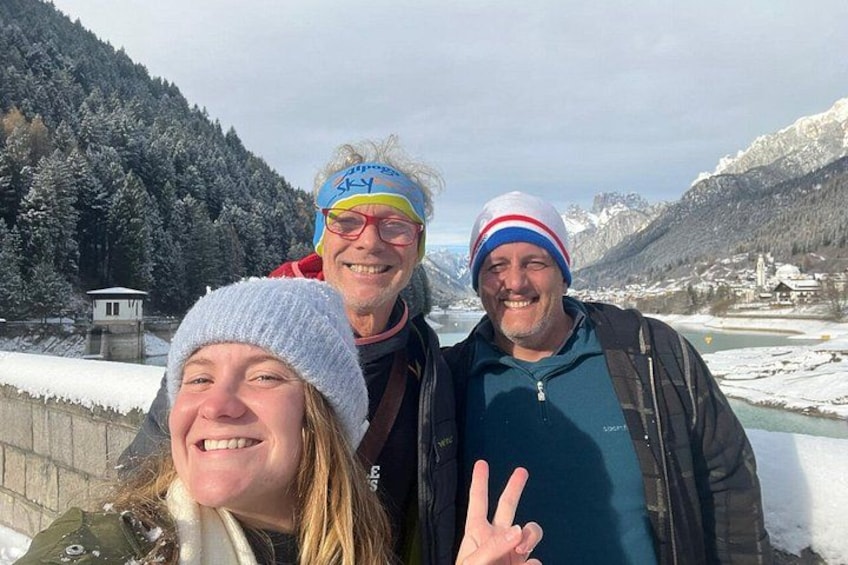 Tre persone in un paesaggio innevato con montagne sullo sfondo. 5
