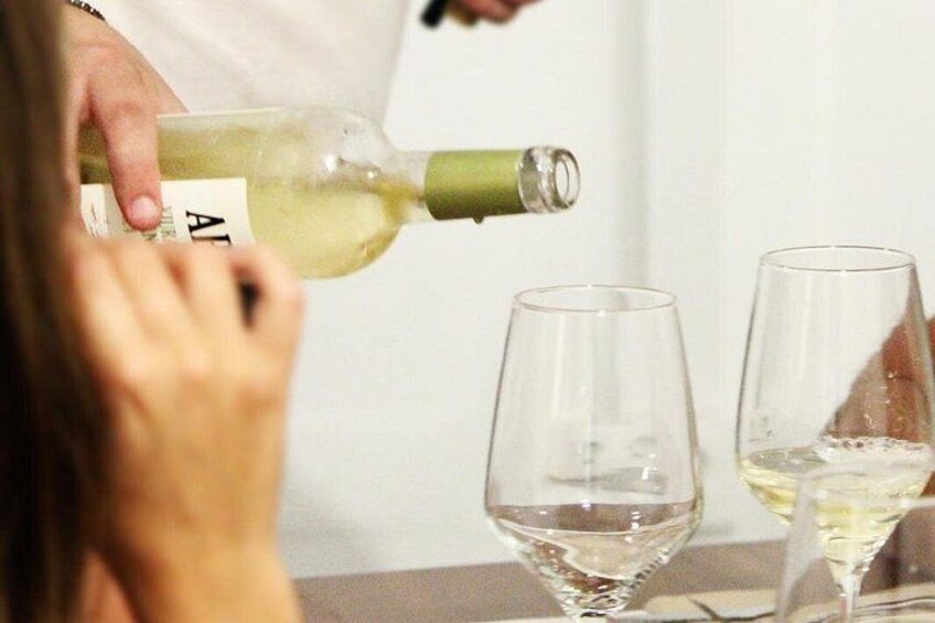 A person pouring a white liquid from a bottle into a glass. 1
