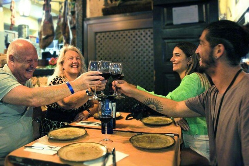 A group of people toasting with wine glasses at a table. 2