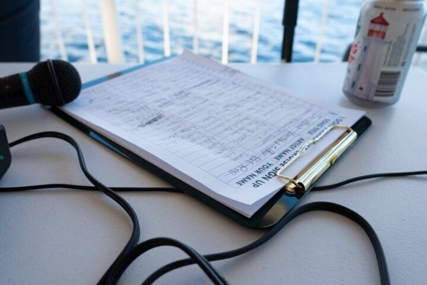 A clipboard with a document, a microphone, and a can of soda on a table. 2