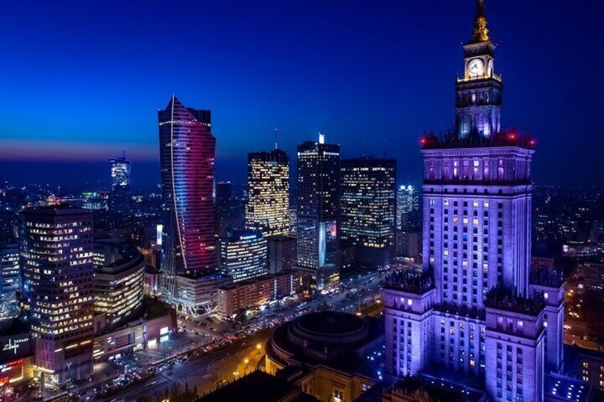 A cityscape at night with illuminated buildings, including a prominent clock tower and modern skyscrapers. 5