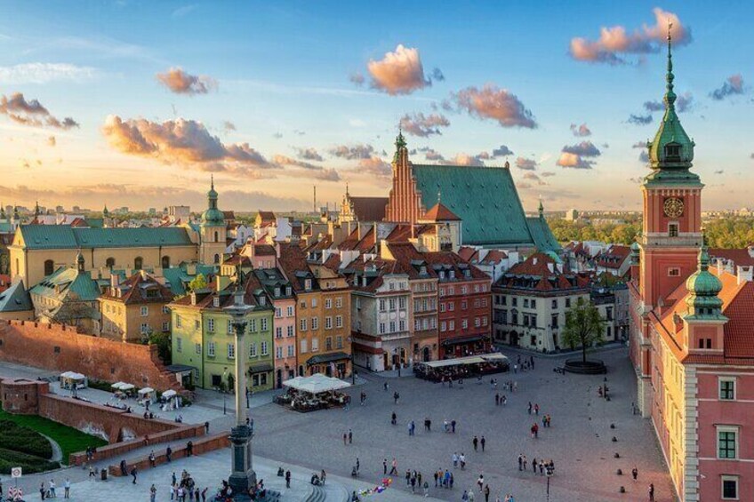 A historic square with colorful buildings, a prominent church, and a clock tower. 2