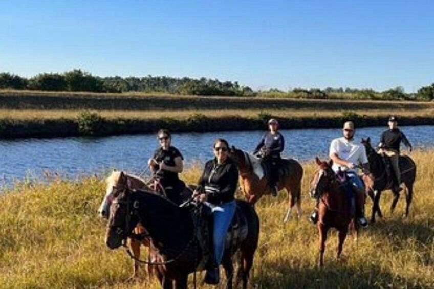 Een groep mensen op paarden in de buurt van een waterlichaam. 4