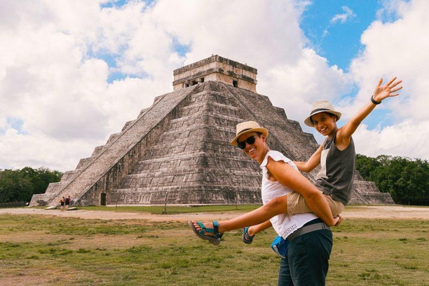 Una gran estructura piramidal con turistas en primer plano. 1