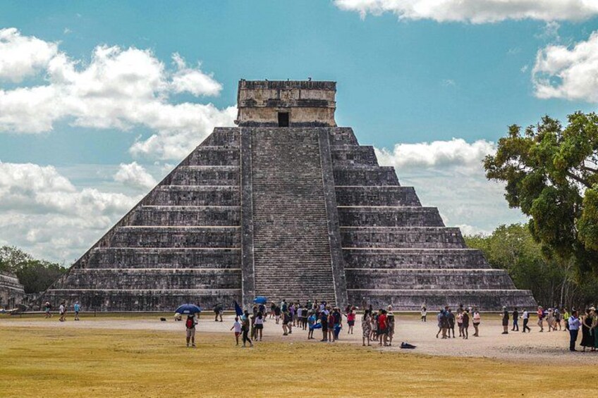 Una pirámide grande con turistas a su alrededor. 4