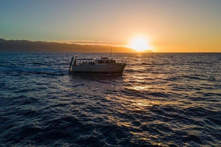 A boat on calm water during sunset with a clear sky. 1