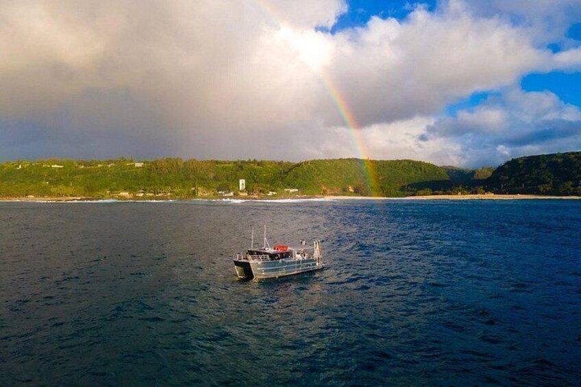 A boat on calm waters with a rainbow in the background. 3