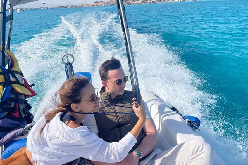 Una embarcación con dos personas, una de ellas lleva chaleco salvavidas, navegando sobre aguas con olas. 5