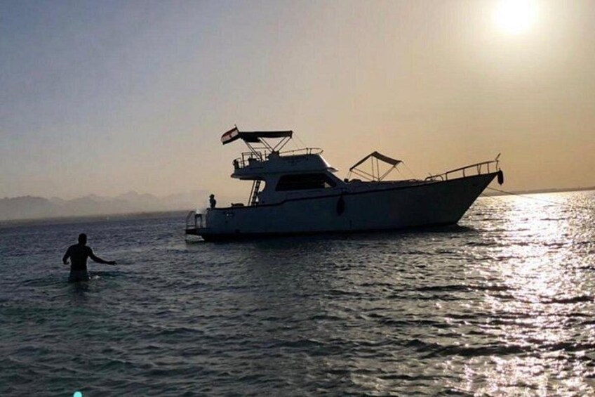 Un bote sobre aguas tranquilas con una persona vadeando al frente. 1