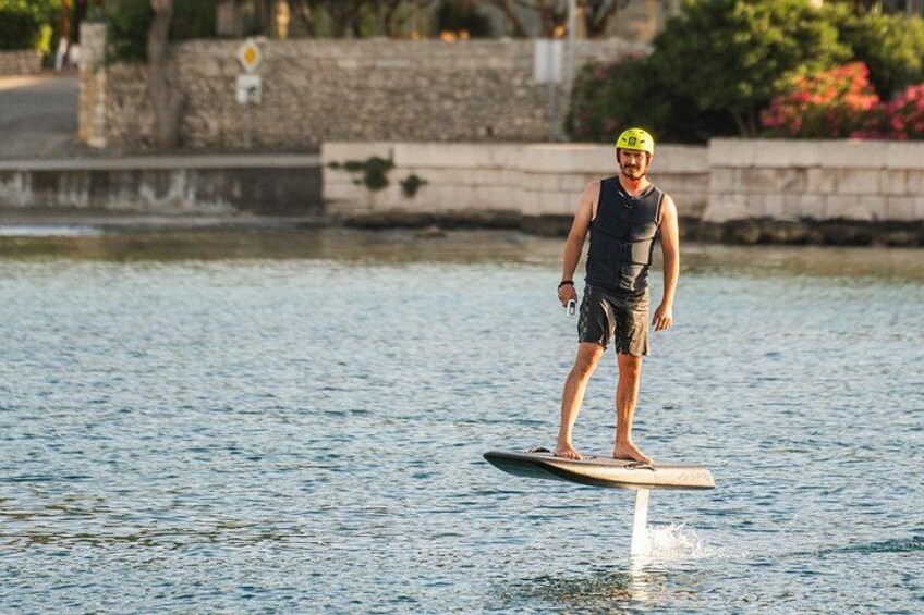 A person standing on a paddleboard in a body of water. 1