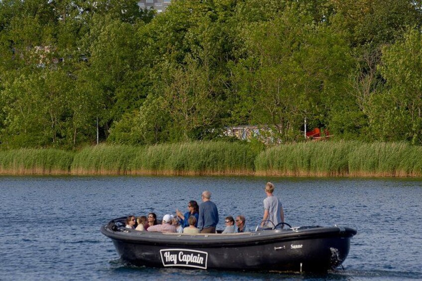 Ein Boot mit dem Namen 'Hey Captain' auf einem See, umgeben von viel Grün. 3
