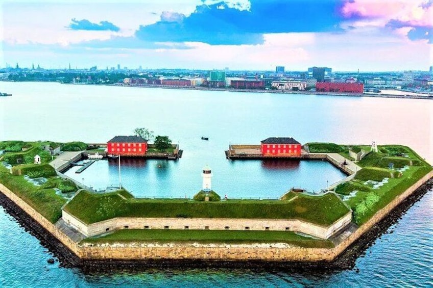 Eine befestigte Insel mit einem Leuchtturm, umgeben von Wasser. 5