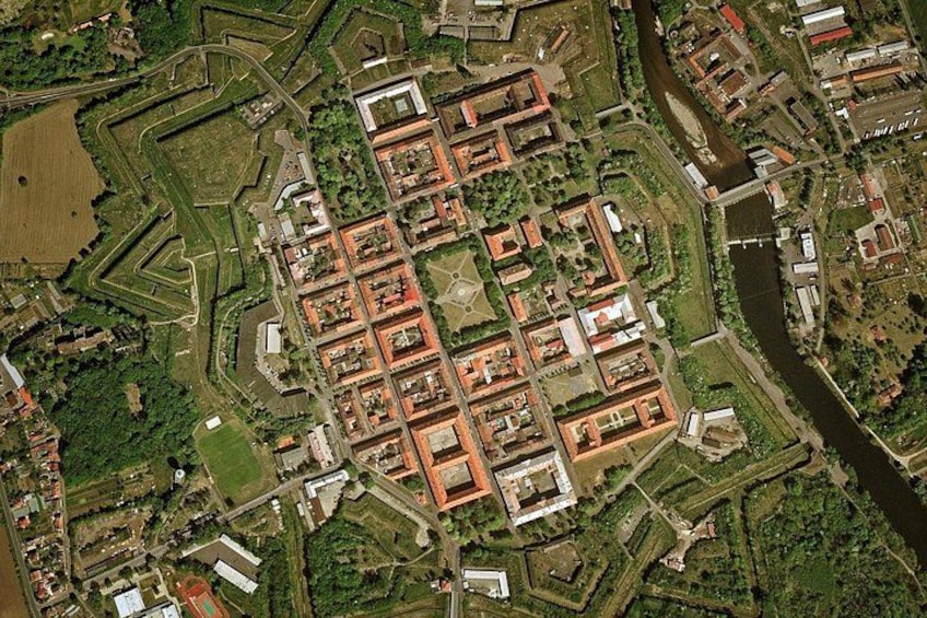 An aerial view of a fortified city with a central square, surrounding walls, and a river. 2