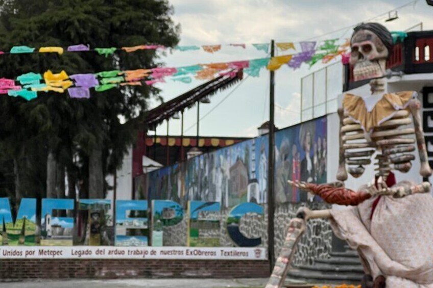 Una escultura de esqueleto y decoraciones coloridas en un entorno urbano. 5