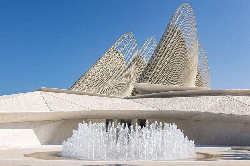 A modern architectural structure with a water fountain in front. 2