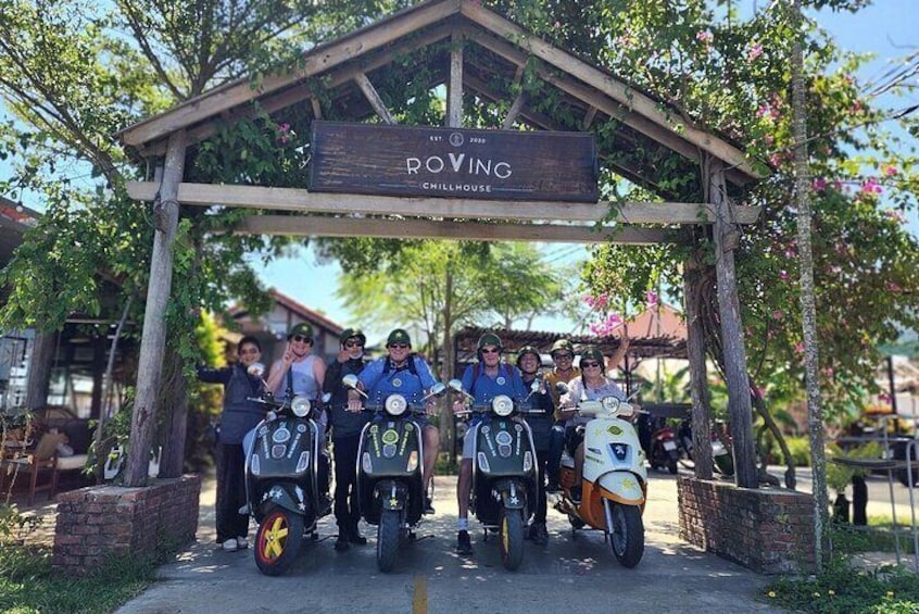 A group of people on scooters under a wooden archway with a sign that reads "POVING CHILLHOUSE". 2