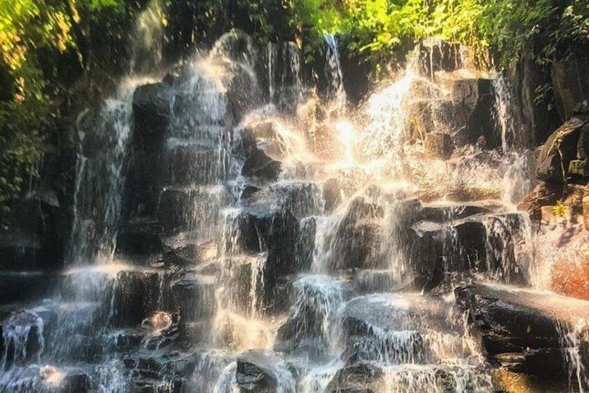 A multi-tiered waterfall surrounded by dense foliage. 1
