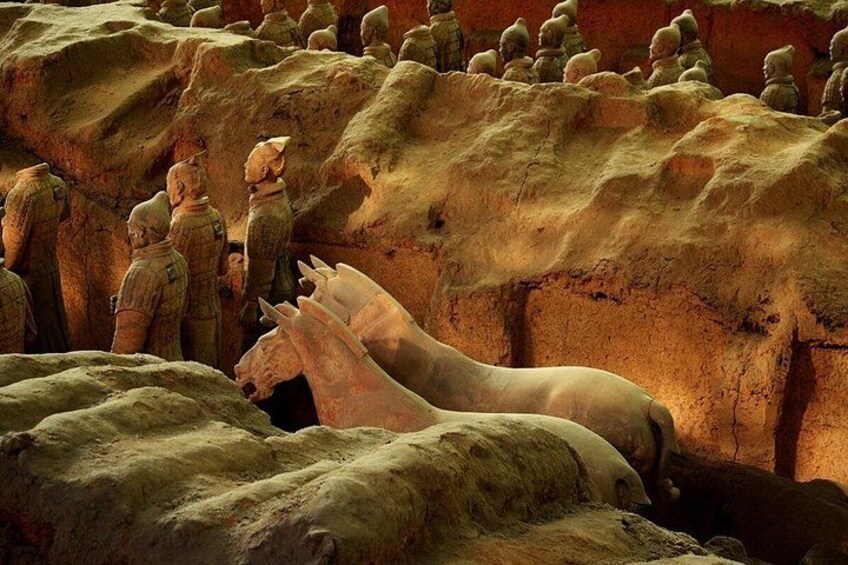 Terracotta soldiers in a row, a large horse, and a rocky terrain. 1