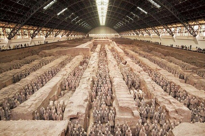 A large indoor exhibition of terracotta soldiers arranged in rows. 3