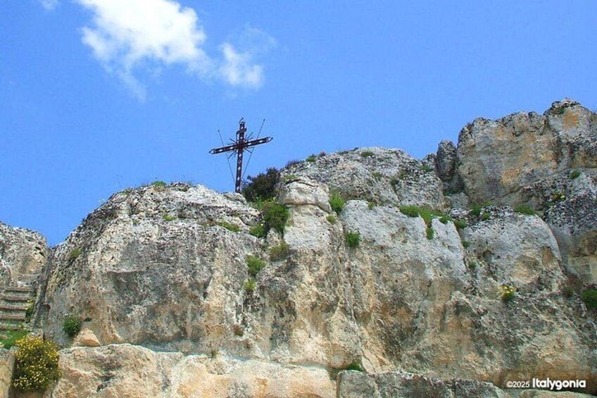 Un paisaje rocoso con una cruz en la cima de una colina. 2