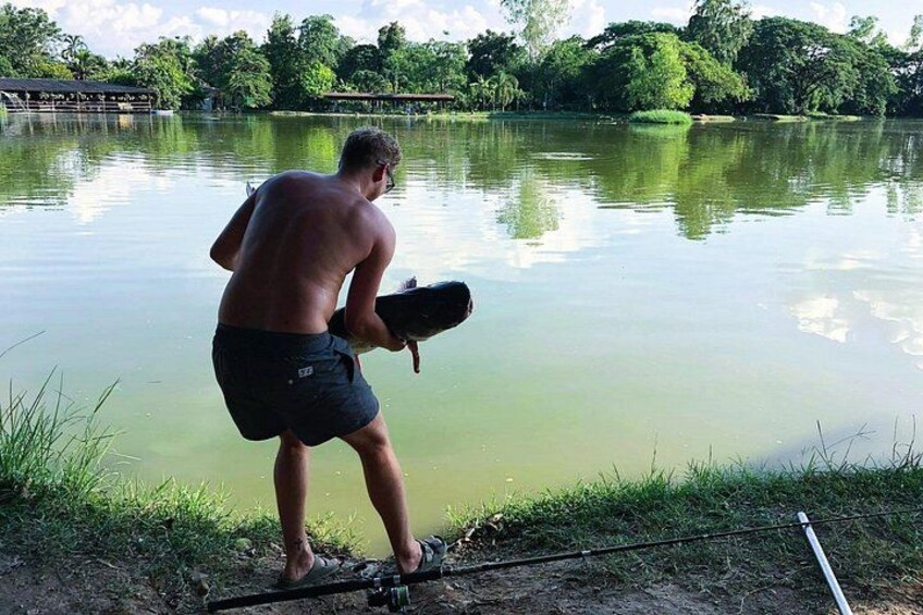 A person standing by a calm lake holding a paddle. 4