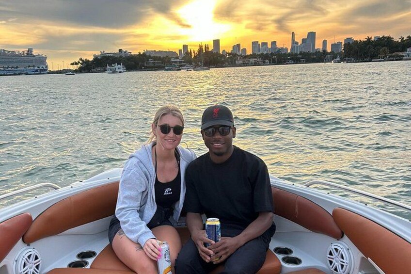 Deux personnes se trouvent sur un bateau, avec la silhouette d’une ville en arrière-plan. 3
