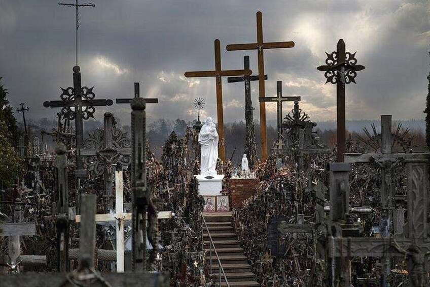 A cemetery with numerous crosses and a central statue. 1
