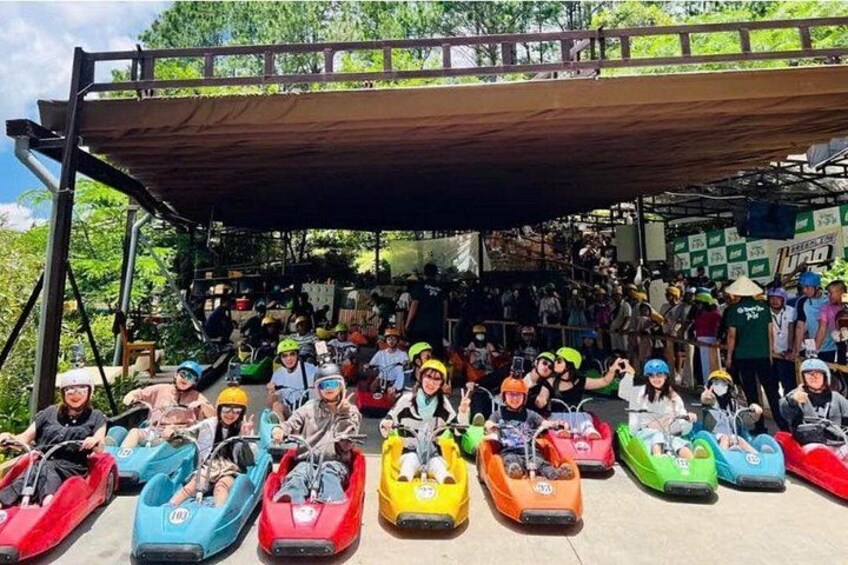 A group of people in colorful bumper cars at an outdoor amusement park. 1