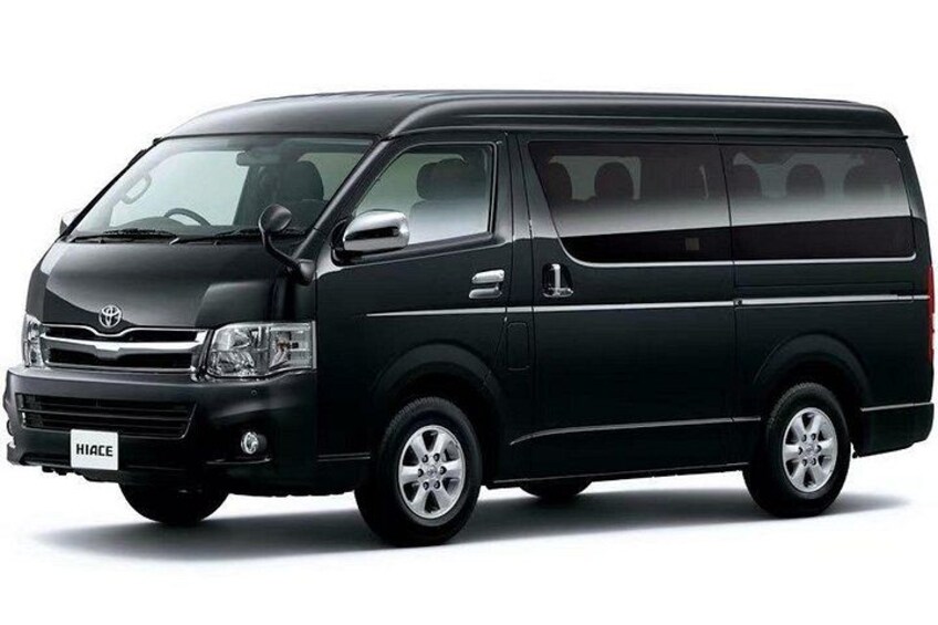 A black Hiace van with a visible license plate, side mirrors, and alloy wheels. 2