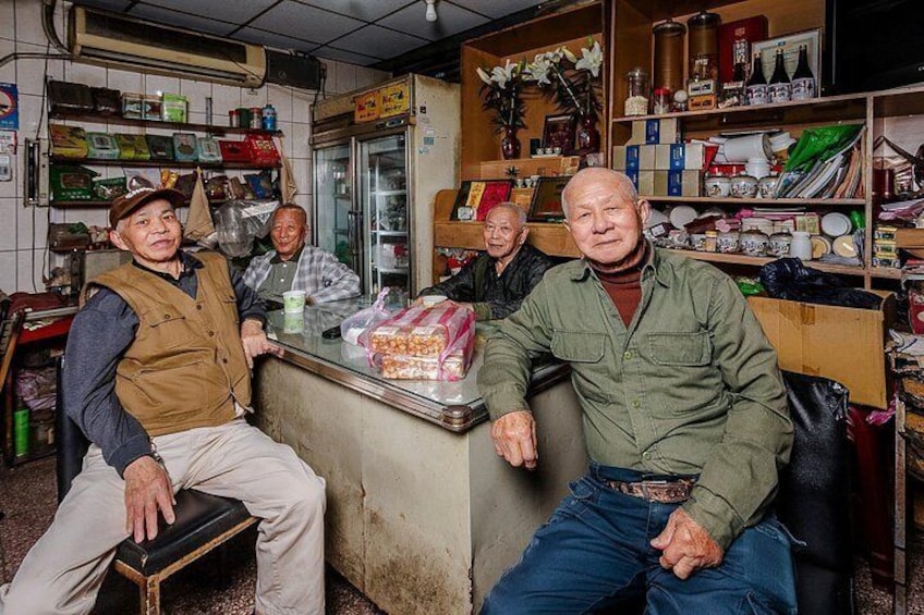 Een winkelinterieur met schappen vol producten, een koelkast en een toonbank met goederen. 3