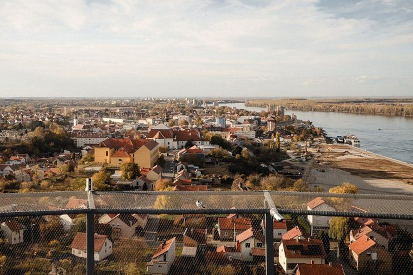 A river with buildings along its banks, a bridge, and a distant city skyline. 3