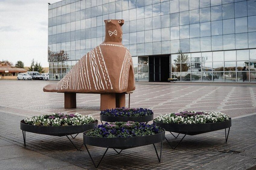 A large ceramic sculpture in front of a modern building. 5