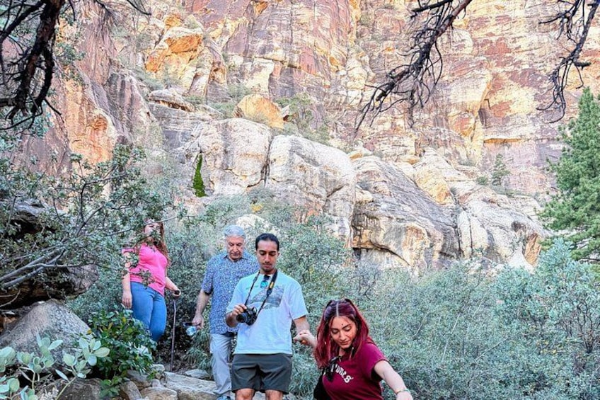 A group of people hiking in a rocky canyon with sparse vegetation. 3