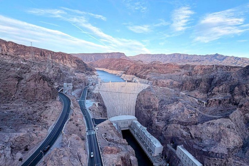 A dam with a road passing through it, surrounded by rocky terrain. 2