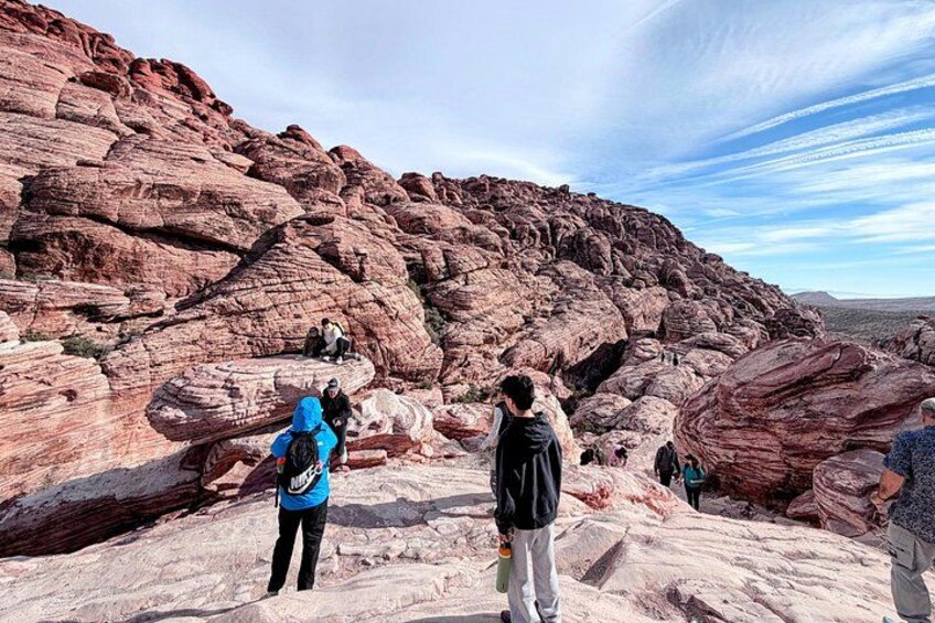 A rocky landscape with people standing on a ledge. 5