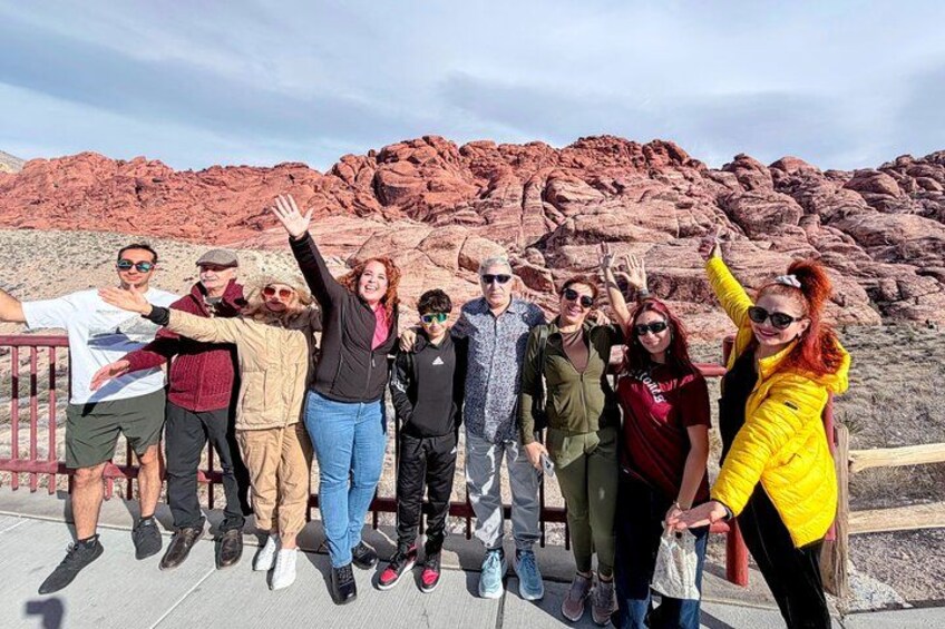 A group of people posing in front of red rock formations. 1