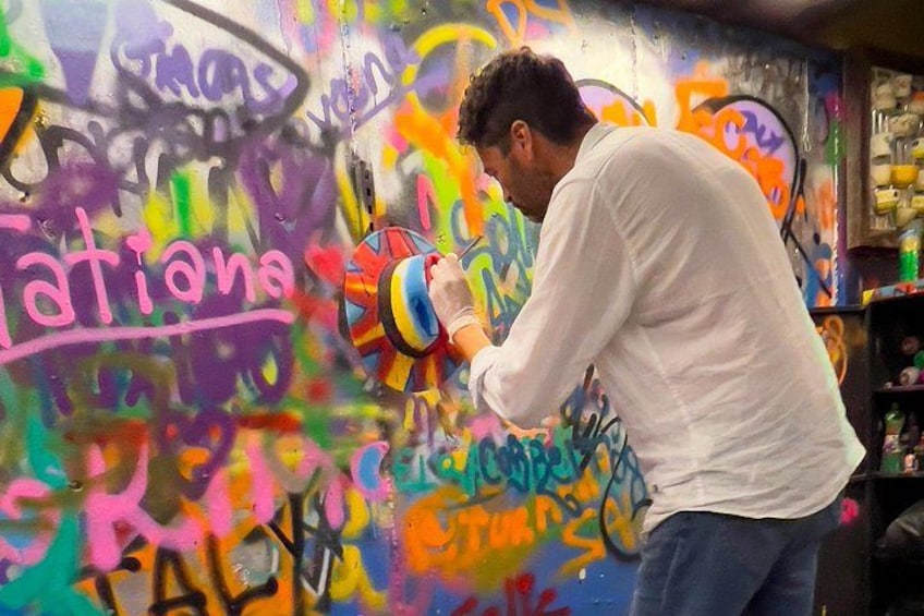 A person painting graffiti on a wall. 1