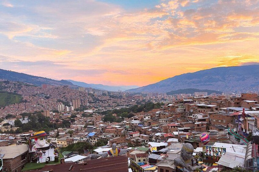 A cityscape with a sunset, buildings, and a distant mountain range. 3
