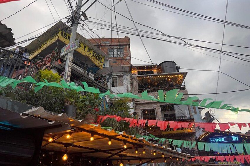 A street with buildings, power lines, and a sign that reads 'DOS ME'. 2