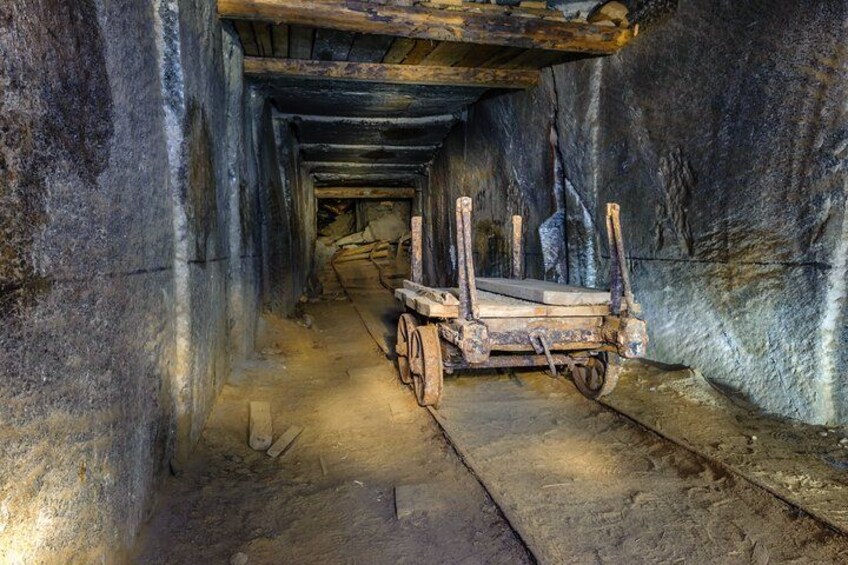 An underground tunnel with a wooden cart. 4
