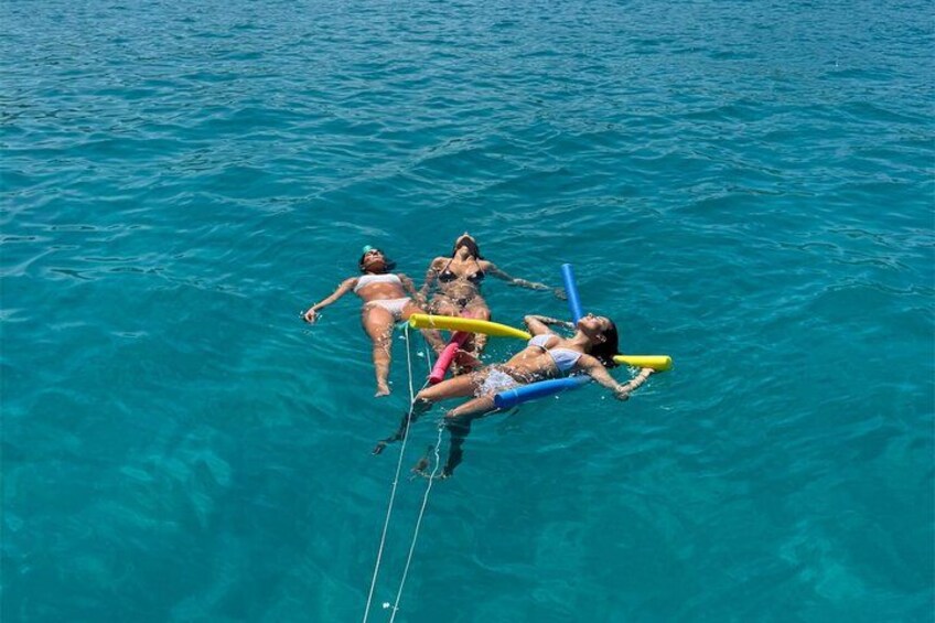 Three people floating on the water with snorkels and fins. 3