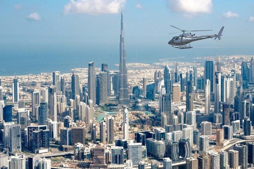 A cityscape with a prominent skyscraper and a helicopter flying above. 3