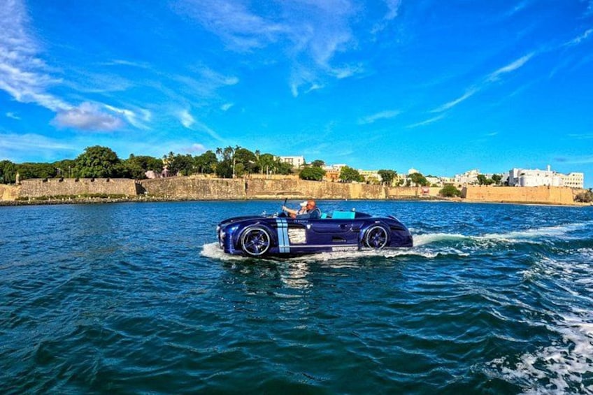 A blue convertible car driving on water. 2