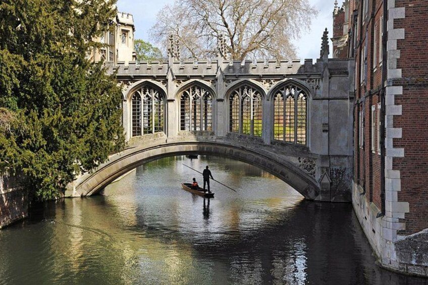 A stone bridge over a river, with a person rowing a small boat. 1