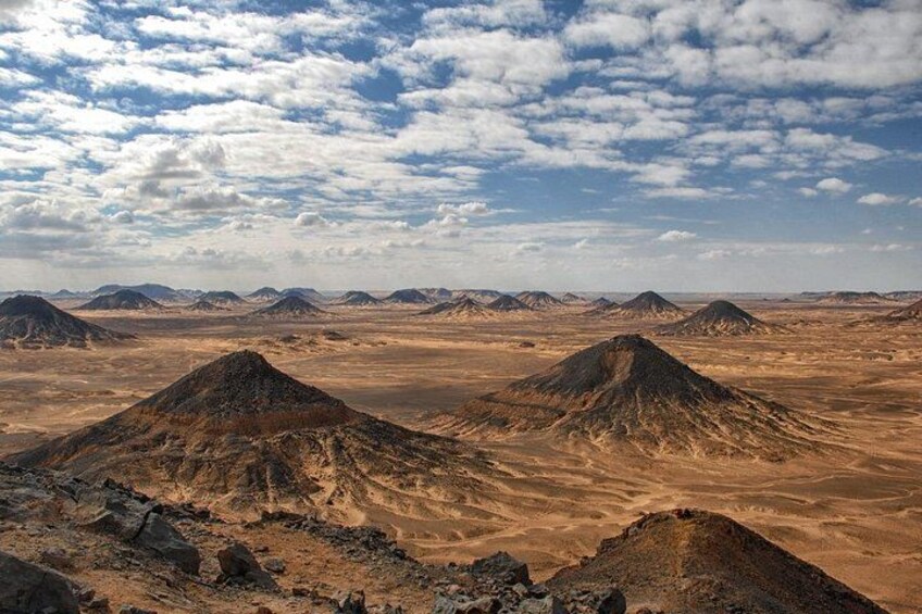 A desert landscape with multiple hills and a clear sky. 4