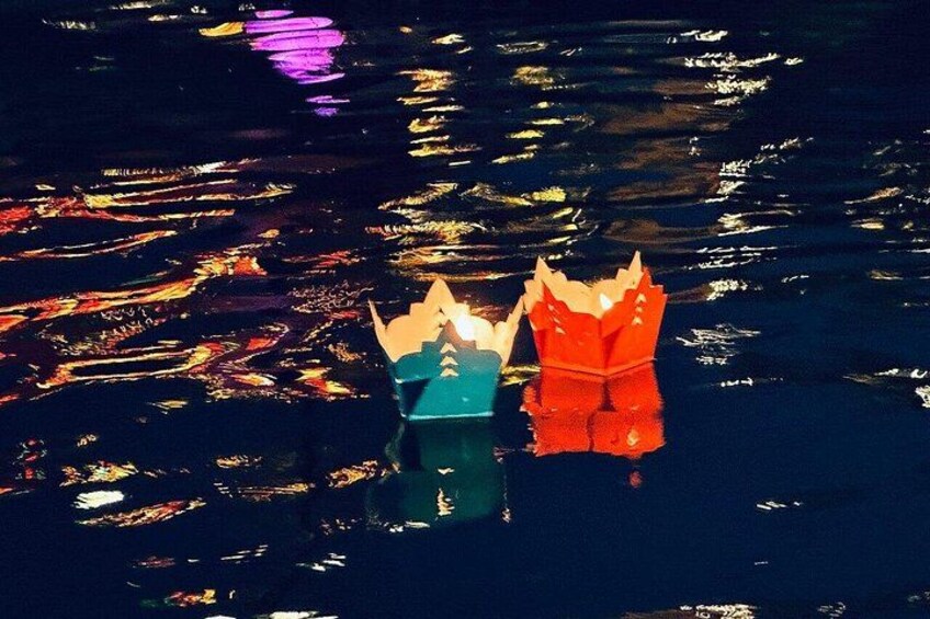 Two paper crowns on water with reflections. 3