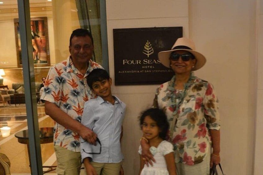 Una familia de cuatro personas frente al letrero de un hotel. 2